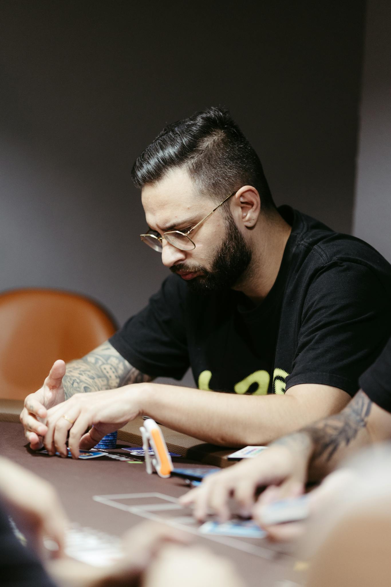 A man concentrating intensely during a poker game at a casino indoors.